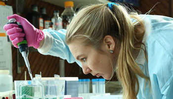 A young woman conducts an experiment in a science lab.