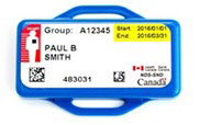 A front view of a single dosimeter that is rectangular in shape and royal blue in color that has an aperture at the top and bottom. Printed on a white label is Group: A12345 and the users name Paul B Smith printed below. The dosimeter serial number 483031 is printed at the very bottom of the white label with a 3D barcode to the left and another 3D barcode to the right. The wearing period start date 2016/01/01 and end date 2016/03/31 is printed in the top right corner and is hightlighted in a yellow textbox. The Health Canada logo appears in the bottom right corner of the white label and just below this is the acronym NDS-SND. The top left side of the label has a red rectangular textbox with InLight centred above a character that has a black square box placed over the heart area.