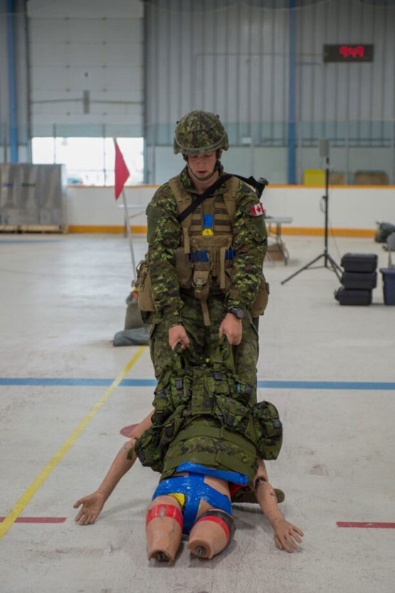 A soldier dragging a mannequin across the ground